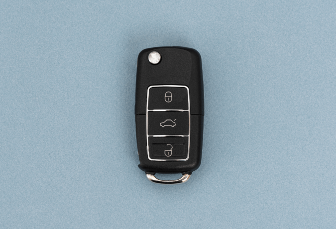 A car key on a vibrant blue background, programmed using an advanced car key programming machine.