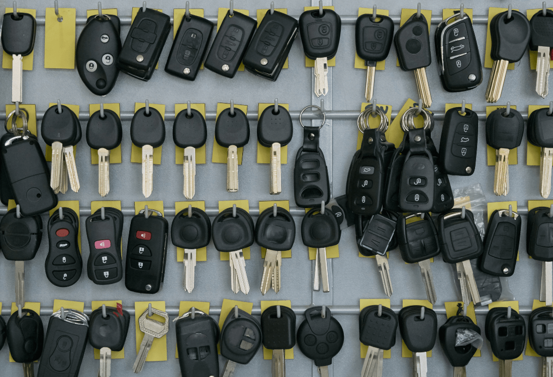 Fobs hanging on a hook after being altered by a car key reprogramming tool.