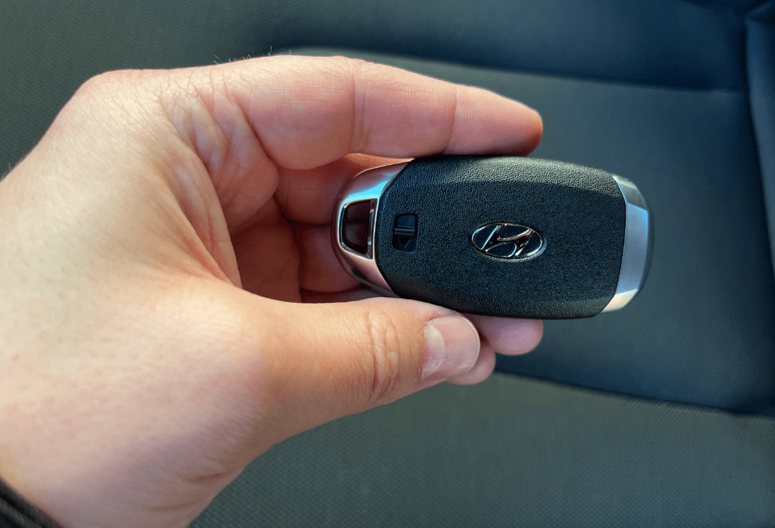 Someone holding a Hyundai smart fob key.