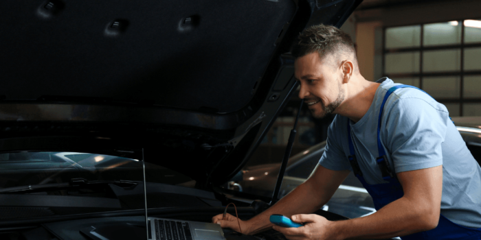 Garage Owner With Laptop Doing Car Diagnostic Tool Update With TDB1000 Software